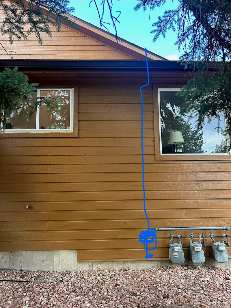 Assessment photo with the proposed vent pipe route drawn on the exterior of the home