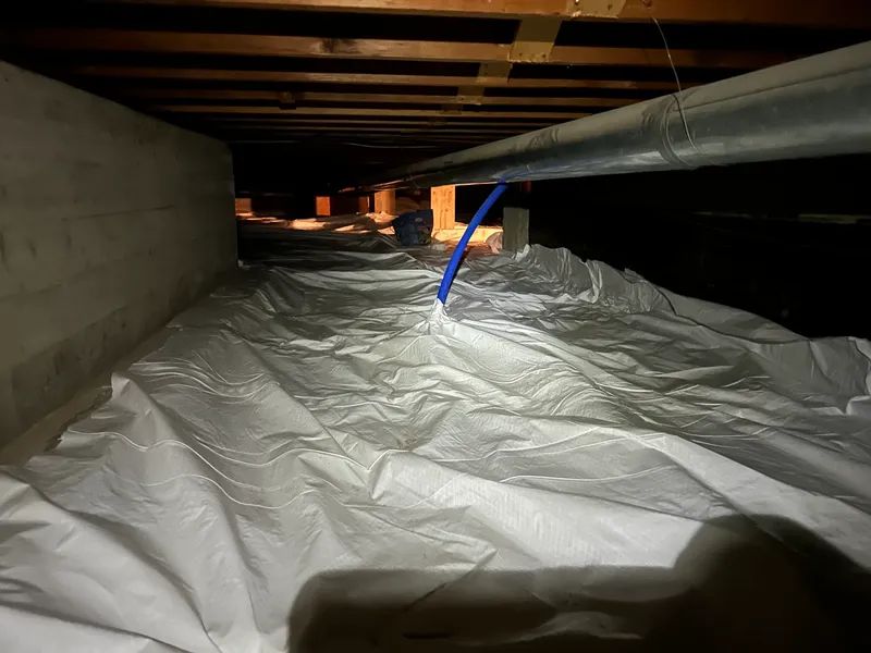 Sealed crawlspace with white vapor barrier installed for sub-membrane radon mitigation